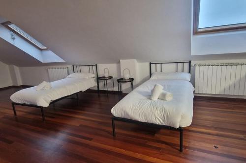 two beds in a room with wood floors at 1A119 El Sangar Somio in Gijón