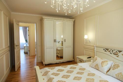 a bedroom with a bed and a chandelier at Boutique Apartments Siguldas in Liepāja