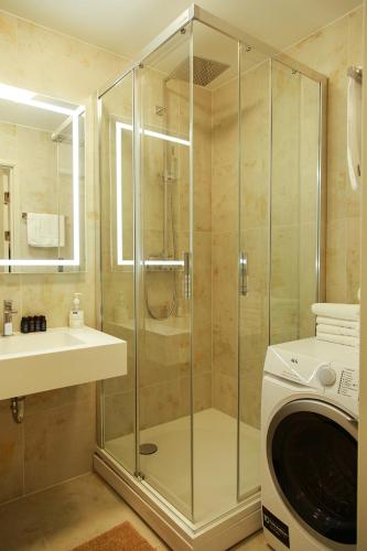 a bathroom with a shower and a washing machine at Boutique Apartments Siguldas in Liepāja
