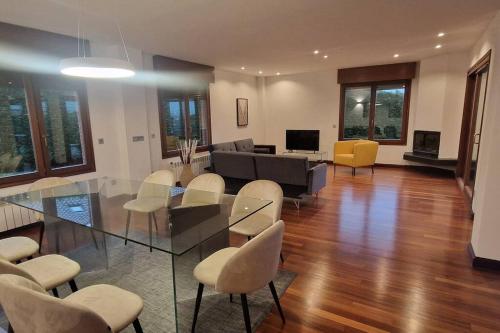 a living room with a glass table and chairs at 1A119 El Sangar Somio in Gijón