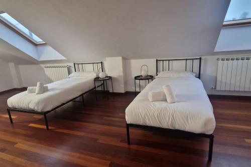 two beds in a room with wooden floors at 1A119 El Sangar Somio in Gijón