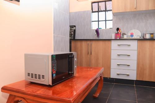 a microwave sitting on top of a wooden table in a kitchen at Tamwe ltd agency in Meru