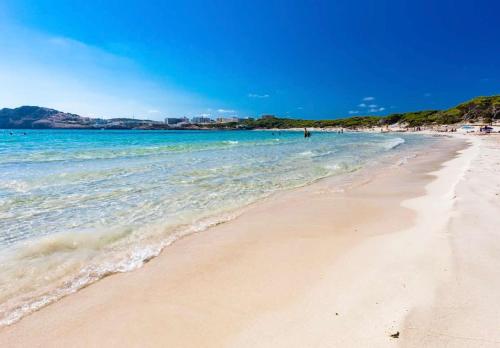 a beach with the ocean and people in the water at APARTMENT MAGALUF in Torrenova