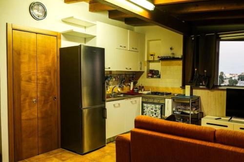 AdelfiaにあるAttico Oasi di Relax Adelfiaのキッチン(ステンレス製の冷蔵庫、ソファ付)