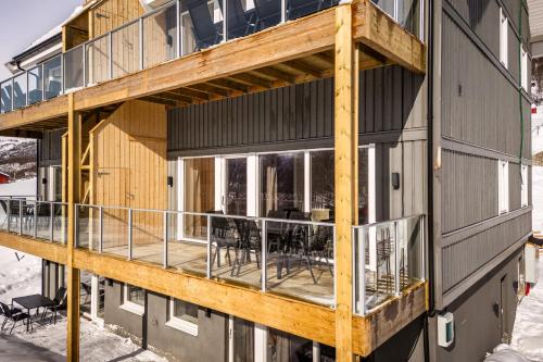 a wooden house with a deck on the side of it at Gullstein in Geilo