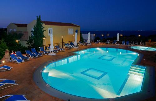 a swimming pool at night with chairs and a building at Sea View Resorts & Spa in Karfas