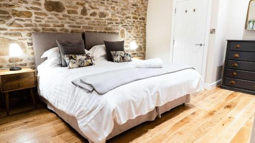 um quarto com uma cama grande e uma parede de pedra em Oak Tree Farm em Buxton