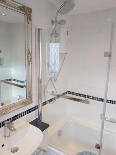 a white bathroom with a shower and a sink at Cornstore in Saint Florence
