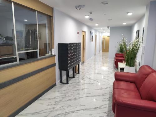 a lobby with a red couch and chairs in a building at Liverpool Stays - Kempston Court in Liverpool