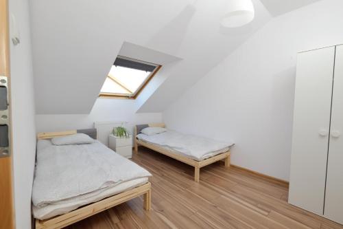 a bedroom with two beds and a window at Apartament Słoneczny 4 in Opole