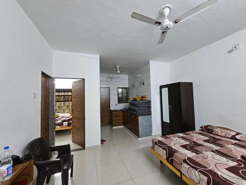 - une chambre avec un lit et un ventilateur de plafond dans l'établissement Madhav Homestay, à Dwarka