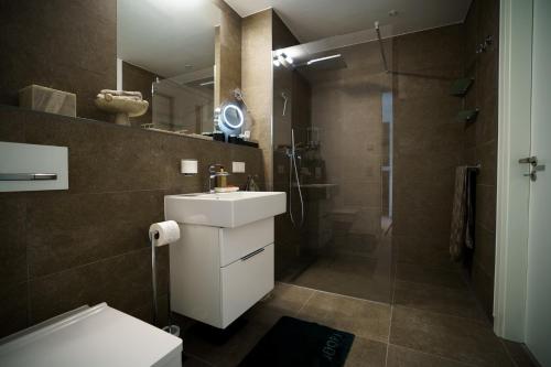 a bathroom with a sink and a shower at Skyline Blick Frankfurt - Nahe Messe in Frankfurt