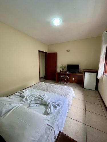 a hotel room with a bed and a television at Pousada Finlândia in Penedo