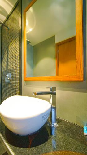 a bathroom with a white sink and a mirror at Hotel Nova Boutique in Rajkot