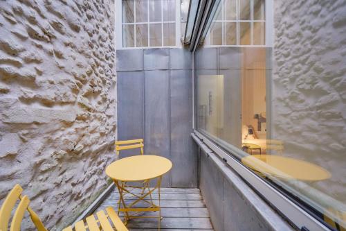 une table et des chaises dans une pièce avec une fenêtre dans l'établissement Le New Vintage - Appt en plein cœur de Bordeaux, à Bordeaux