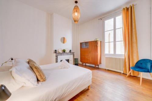 une chambre avec un lit blanc et une chaise bleue dans l'établissement Le New Vintage - Appt en plein cœur de Bordeaux, à Bordeaux