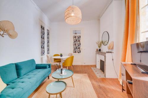 un salon avec un canapé bleu et une table dans l'établissement Le New Vintage - Appt en plein cœur de Bordeaux, à Bordeaux