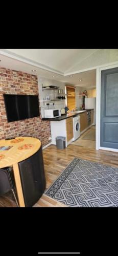 a kitchen with a table and a brick wall at 2 Bedroom Chalet Isle of Sheppey Holiday Village in Kent