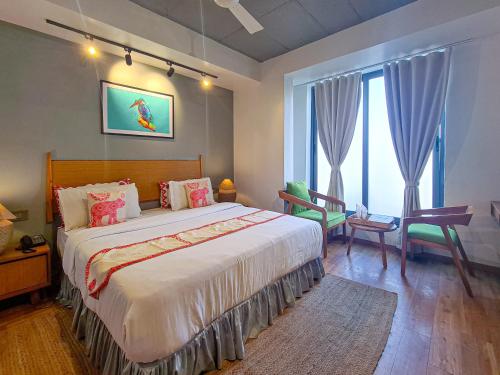 a bedroom with a bed and a desk and a window at Hotel Nova Boutique in Rajkot