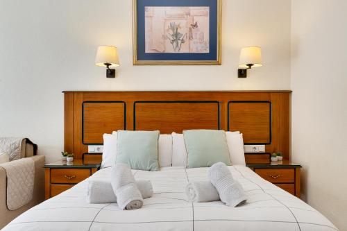 een slaapkamer met een wit bed met 2 kussens bij Solana Fuengirola 40 in Fuengirola
