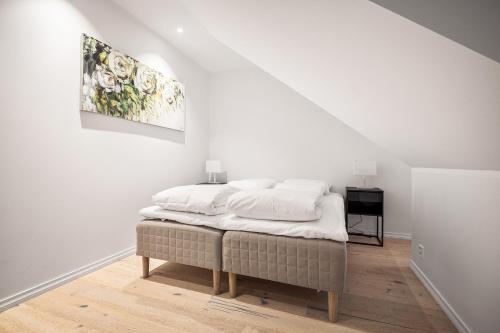 a bed in a white room with a painting on the wall at Gullstein in Geilo