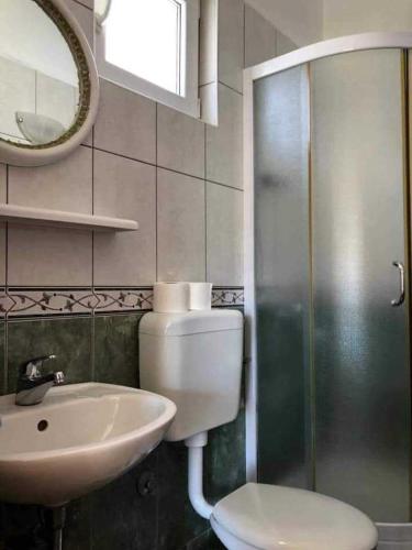a bathroom with a toilet and a sink and a shower at Apartments Natalika in Podaca