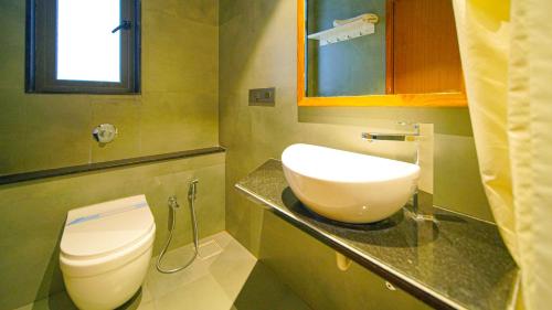 a bathroom with a toilet and a sink at Hotel Nova Boutique in Rajkot