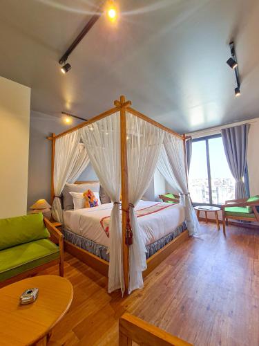 a bedroom with a canopy bed and a living room at Hotel Nova Boutique in Rajkot