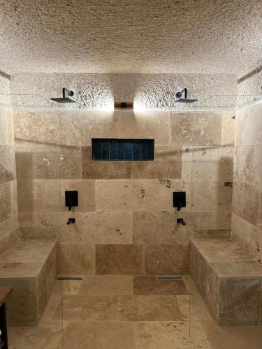 a large bathroom with a shower with stone tiles at Casa Chilai Cappadocia in Ürgüp
