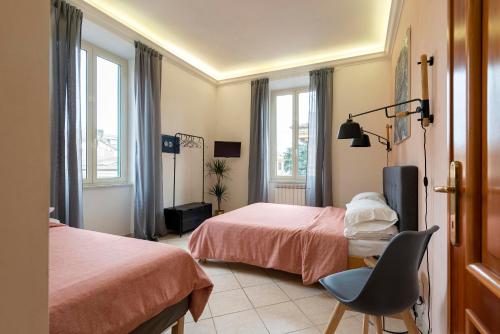 una camera con due letti e una sedia e finestre di Redseven Rome Apartment a Roma