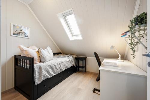 um pequeno quarto com uma cama e uma janela em Top-floor apartment w/great view em Bergen