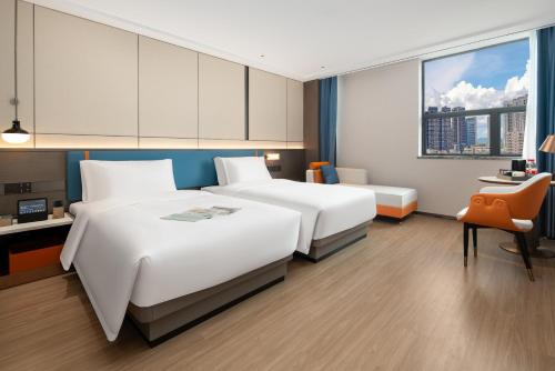 מיטה או מיטות בחדר ב-Yizhi Hotel - Guangzhou East Railway Station Tianhe Sports Center