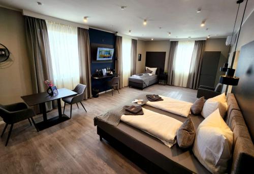 a large bedroom with a large bed and a living room at Liro Hotel Oberhausen in Oberhausen