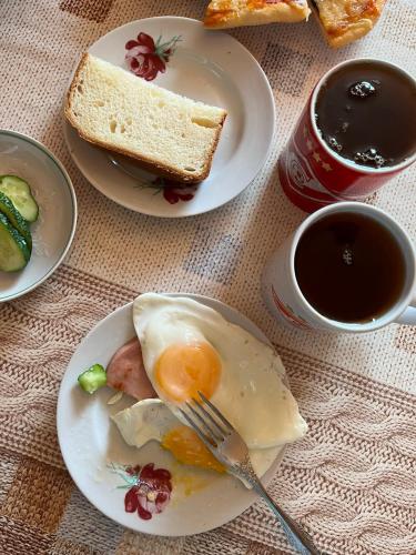 a plate with an egg and bread and a cup of coffee at Quba ALFA-M Motel in Quba