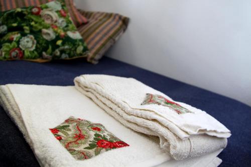 dos toallas blancas sentadas en una mesa con una almohada en Casa Toníca, en Crato
