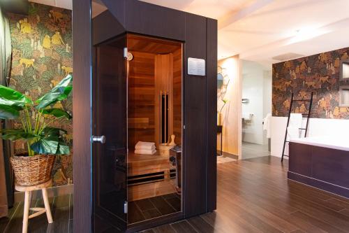 a bathroom with a glass door leading into a bathroom with a tub at Van der Valk Drachten in Drachten