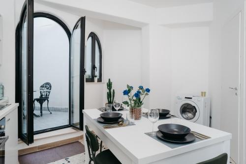 a white kitchen with a table with two bowls on it at Vista Napoli Residence - Il Cortile in Naples