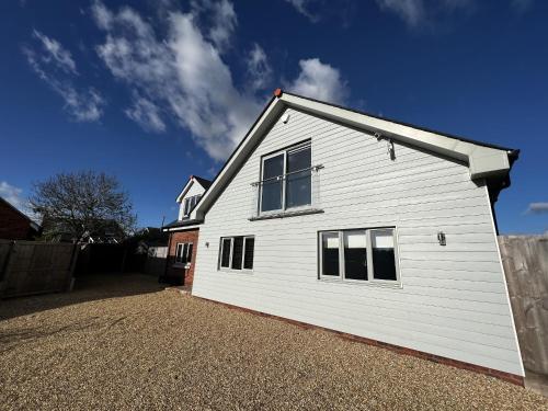 a white house with windows on the side of it at Laurel Cottage in Sandown