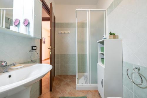 a bathroom with a white sink and a shower at Casa vacanze sole e mare in Porto Pino