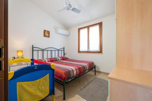 a small bedroom with a bed and a window at Casa vacanze sole e mare in Porto Pino