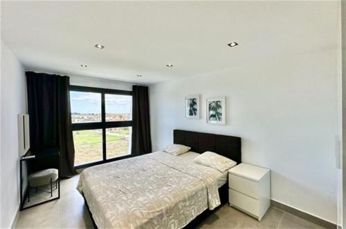 a bedroom with a bed and a large window at White Lion Apartment N2 Kallithea in Kallithea Halkidikis