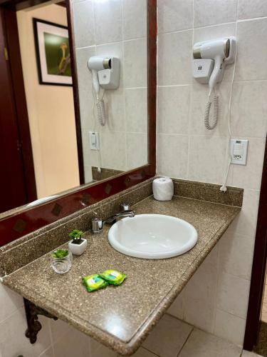 a bathroom counter with a sink and a mirror at Pousada Finlândia in Penedo
