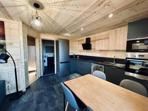 een keuken met een houten plafond en een houten tafel bij Au P'tit Randonneur avec terrasse - CLG - 1CH - 1 SDB in Chevillard