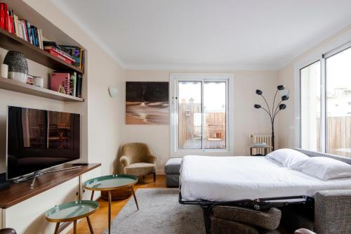 Schlafzimmer mit einem Bett und einem TV in der Unterkunft Veeve - Chaillot Skies in Paris
