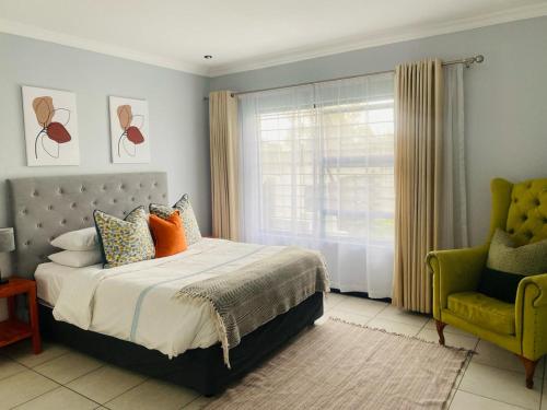 1 dormitorio con 1 cama, 1 silla y 1 ventana en Comfort in Glen Austin, Midrand, en Midrand