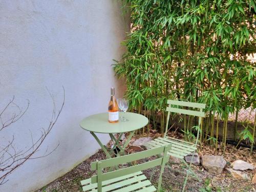 - une table avec une bouteille de vin et 2 chaises dans l'établissement Joli studio lumineux centre avec parking securise dans quartier recherche, à Aix-en-Provence