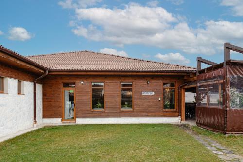 a home with a wooden house with a yard at Casa Dinainte Young and Adults Only in Sălicea