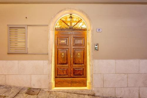 a wooden door with an arched window on a building at Palazzo Falcinelli Luxury Room in Montepulciano Center with Air Conditioning and Elevator in Montepulciano