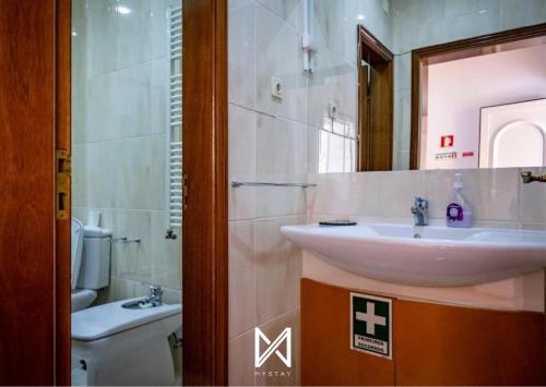 a bathroom with a sink and a toilet and a mirror at MyStay - Casa Pereira Soeima in Alfândega da Fé