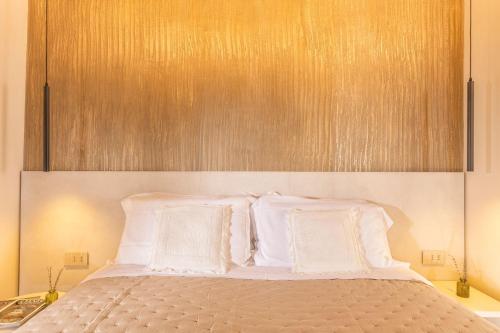 a bed with white pillows and a wooden headboard at Palazzo Falcinelli Luxury Room in Montepulciano Center with Air Conditioning and Elevator in Montepulciano